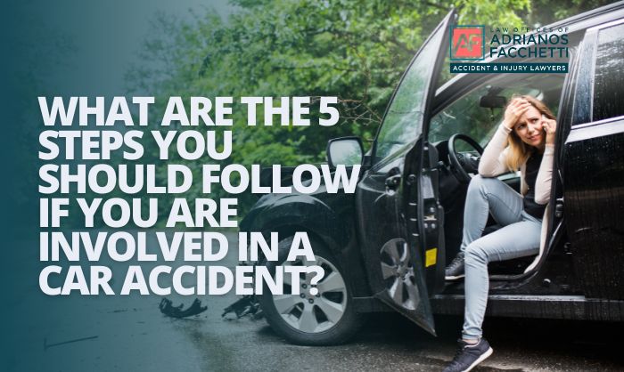 Woman sitting in damaged car holding her head after crash, representing steps to take after a car accident in California