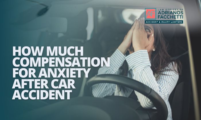 A woman sitting in her car visibly distressed, covering her face with both hands after a car accident