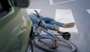 Bicycle accident scene in a Long Beach crosswalk next to a car